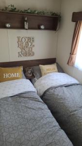 two beds sitting next to each other in a bedroom at Gloria Stay - Aberystwyth Caravan in Aberystwyth