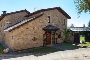 un gran edificio de piedra con una puerta grande en Villa Rural "La casa de ANA", en Muelas de los Caballeros