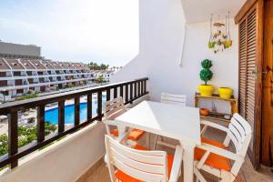 Un balcón con mesa y sillas y vista al mar. en Rentaliday Palmera Canaria, en Playa de las Américas