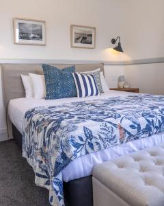 
a bed with a white comforter and pillows at Bermagui Beach Hotel South Coast in Bermagui
