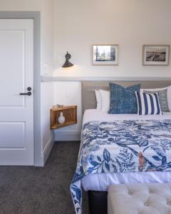 
a bedroom with a bed and a dresser at Bermagui Beach Hotel South Coast in Bermagui
