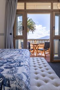 
a hotel room with a bed, chair and a window at Bermagui Beach Hotel South Coast in Bermagui
