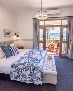 
a bedroom with a bed, chair, table and window at Bermagui Beach Hotel South Coast in Bermagui

