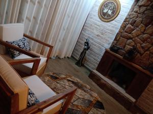 蒙特沃德的住宿－Casa Recanto Beija Flor, Monte Verde，客厅设有壁炉和沙发。