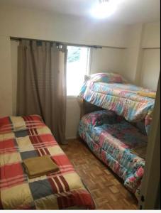 um quarto com 2 camas individuais e uma janela em Departamento Av. Colon (Ubicacion 9.8 puntos) em Mendoza