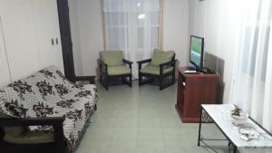 a room with a bed and two chairs and a television at Casa chalet en Solanas Portezuelo Punta ballena in Punta del Este