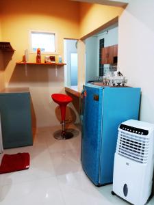een keuken met een blauwe koelkast en een rode kruk bij Guesthouse - Biru Homestay in Tjilimus