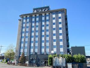 um edifício com uma placa no topo em Hotel Route-Inn Sanofujioka Inter em Sano