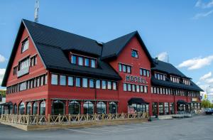 a large red building with a black roof at Hotell Fyrislund in Uppsala