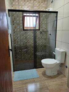ein Badezimmer mit Toilette und Glasdusche in der Unterkunft Sítio da Figueira in Praia Grande + 24 Fotos