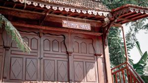 a wooden garage door with a sign on it at Cokro Hinggil - Traditional View in Sleman