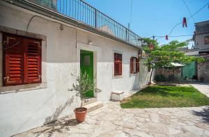 a house with a green door and a potted plant at Dalmatian Garden - FREE parking - city centre in Šibenik
