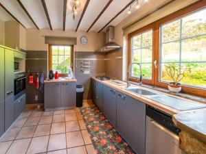 eine Küche mit grauen Schränken und einem großen Waschbecken in der Unterkunft Holiday Home with Garden Terrace and Jacuzzi in season in Vielsalm in Vielsalm