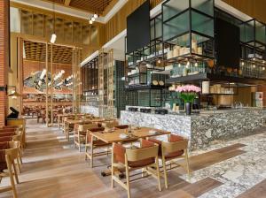 a restaurant with wooden tables and chairs and a bar at Shangri-La Qiantan, Shanghai in Shanghai