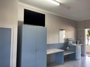 a kitchen with a tv on top of a refrigerator at Cardwell Beachcomber Motel & Tourist Park in Cardwell