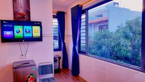um quarto com uma televisão e uma janela com cortinas azuis em Sena home 3#1-Near Danang Dragon Bridge-Han River em Da Nang