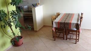 a table and chairs with a table and a kitchen at Apartment Bella in Split
