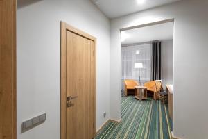 a room with a door and a table and chairs at ParkCity Hotel in Chelyabinsk