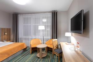 pokój hotelowy z łóżkiem i telewizorem z płaskim ekranem w obiekcie ParkCity Hotel w mieście Czelabińsk