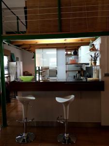 a kitchen with two white stools at a counter at Full rental or by areas. Barbecue, Gardens, Large Terraces, Three rooms in Beniatjar