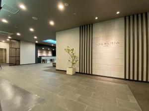 Hotel Route Inn Matsue في ماتسو: لوبي عماره فيها محطه على الحائط
