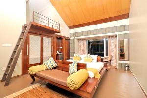 a living room with a couch and a loft bed at Radosri in Coonoor