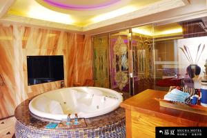 a large bathroom with a large tub and a tv at Mucha Motel in Kaohsiung