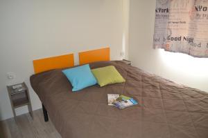 - un lit avec deux oreillers et un livre dans l'établissement VVF Montagnac Hérault, à Montagnac 24 autres photos