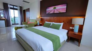 a bedroom with a large bed with green and white sheets at Riverbank Villa in Luodong