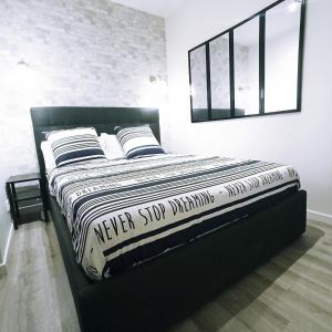 1 cama con marco negro en una habitación en L'appart du Petit Prince By Beds4Wanderlust - Fabuleux T2 avec jardin - Gare Plaisir Grignon, en Plaisir