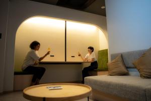 大阪市にあるホテルエスプレッソサウスの二人の女性が飲み物を飲みながら座っている