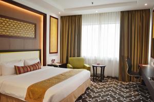 a hotel room with a large bed and a television at Corus Hotel Kuala Lumpur in Kuala Lumpur