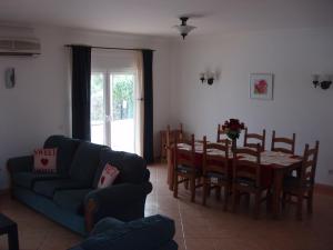 ein Wohnzimmer mit einem Tisch und einem blauen Sofa in der Unterkunft Villa Castelos, Quelfes, Eastern Algarve private pool in Olhão