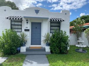 une petite maison blanche avec une porte bleue dans l'établissement Pretty Private Room, near the Airport - Free parking - 01, à Miami