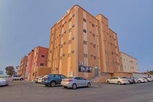 a parking lot with cars parked in front of a building at أويو 590 ديالا للوحدات السكنية in Khamis Mushayt