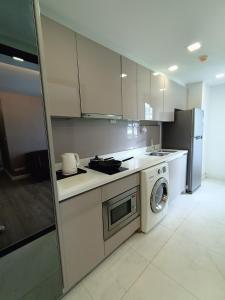 a kitchen with a stove and a washing machine at Residence 187 in Bangkok