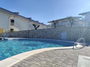 a swimming pool in front of a house at Bilocale in residence vista lago con piscina in Polpenazze del Garda