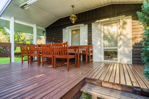a wooden deck with a table and chairs on a house at Domek Przy Plaży in Gąski +4 photos