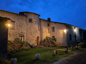 a large stone building with a yard at night at Domaine La Tour in Loubens +4 photos