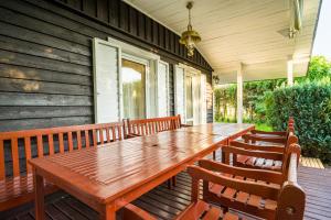 a wooden table on the front porch of a house at Domek Przy Plaży in Gąski