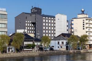 Hotel Route Inn Matsue في ماتسو: مدينة ذات مباني طويلة بجوار نهر