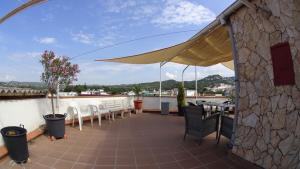 a patio with chairs and a table and an umbrella at Hostal Julieta in Lloret de Mar