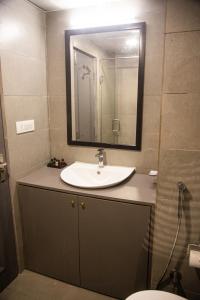 uma casa de banho com um lavatório e um espelho em Golden Parkk Hotel em Calcutá