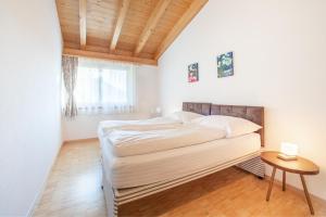 a bedroom with a large bed and a table at Casa Miraval in Flims