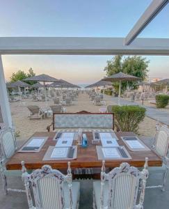a wooden table with chairs and umbrellas on a beach at Venus Resort in Tsilivi