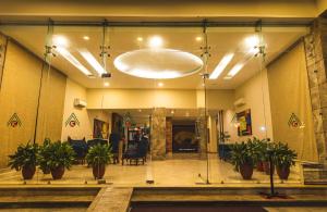 a lobby with potted plants and a large light fixture at Hotel Asia Vaishnodevi in Katra