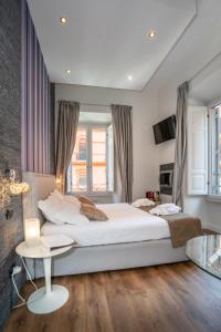 Un dormitorio con una gran cama blanca y una mesa en Vatican Suites - The Luxury Leading Accommodation in Rome en Roma