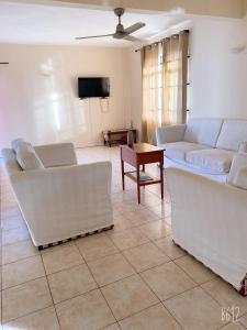 a living room with two couches and a tv at Viksh Seaview Apartment in Rivière Noire