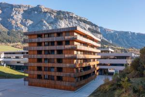 a tall building with a mountain in the background at Vallada 14 01 in Flims