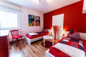 um quarto vermelho com uma cama e uma cadeira em Schalkhaus Regensburg em Regensburg
